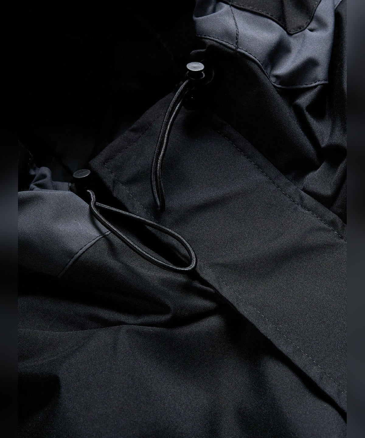 VERTEX - JACKE in Schwarz, Nahaufnahme Kapuze mit Kordelzug und Reißverschluss